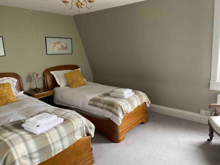 Chambre à deux lits avec salle de bain attenante.  Cette chambre contient également un bureau secret qui est parfait pour un espace de travail calme ou une retraite d'écriture.