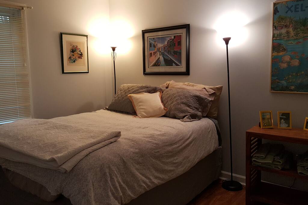 Front room is sunny with a new Queen Bed.