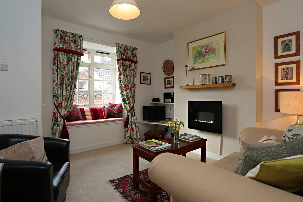 The living room comes with comfy seating and a flat-screen TV