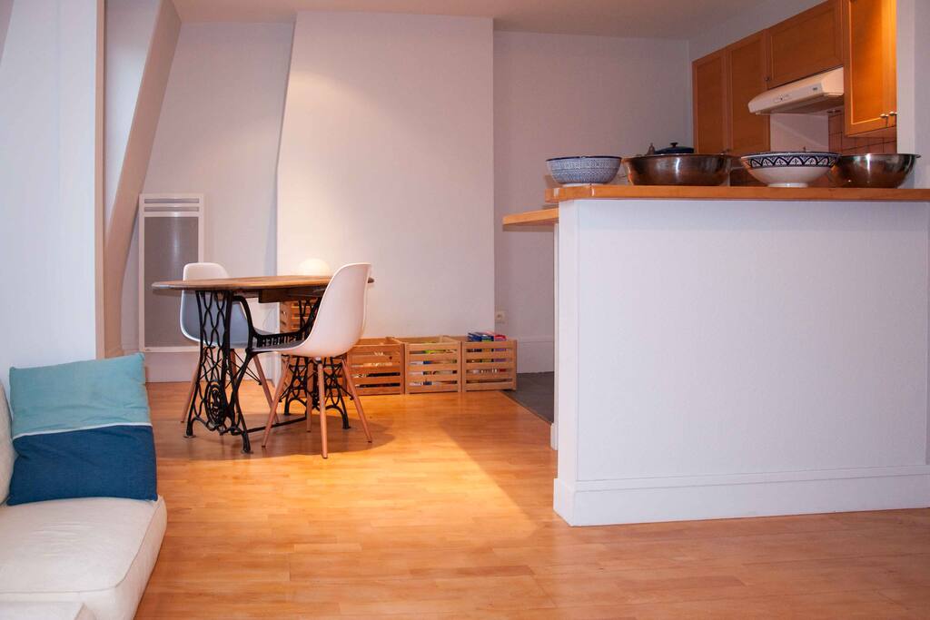 From the living room: dining table and american kitchen