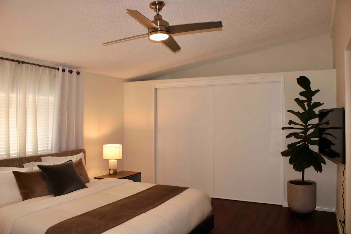 El dormitorio principal cuenta con una cama tamaño king cali, ventilador de techo y un televisor inteligente Samsung.