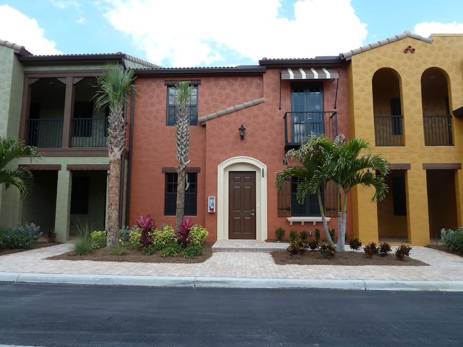 Front of building. Front door is in center with each private lanai on sides. One is in the green side and one is in the gold side. Around back us a 2 car garage. Street parking is also available.