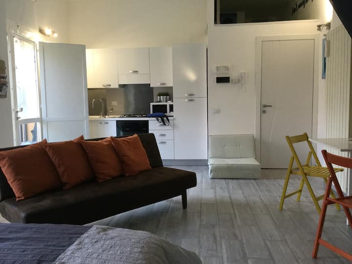 всекидневна с напълно обзаведена кухня, разтегателен диван щракнете върху клик и удобни столове за пуф