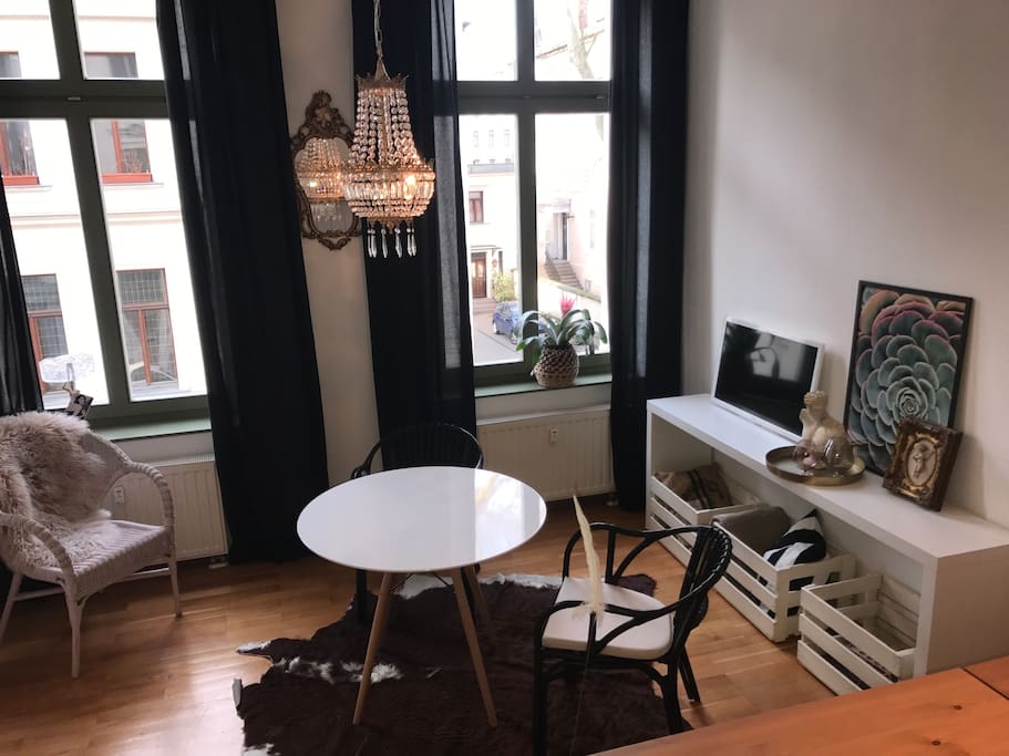 Alt & neu: Antiker Kronleuchter trifft Designertisch und LED-TV im Wohnzimmer