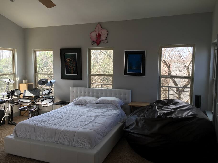 Loft Bedroom with edrums, queen sized bed, and large leather / foam bag chair