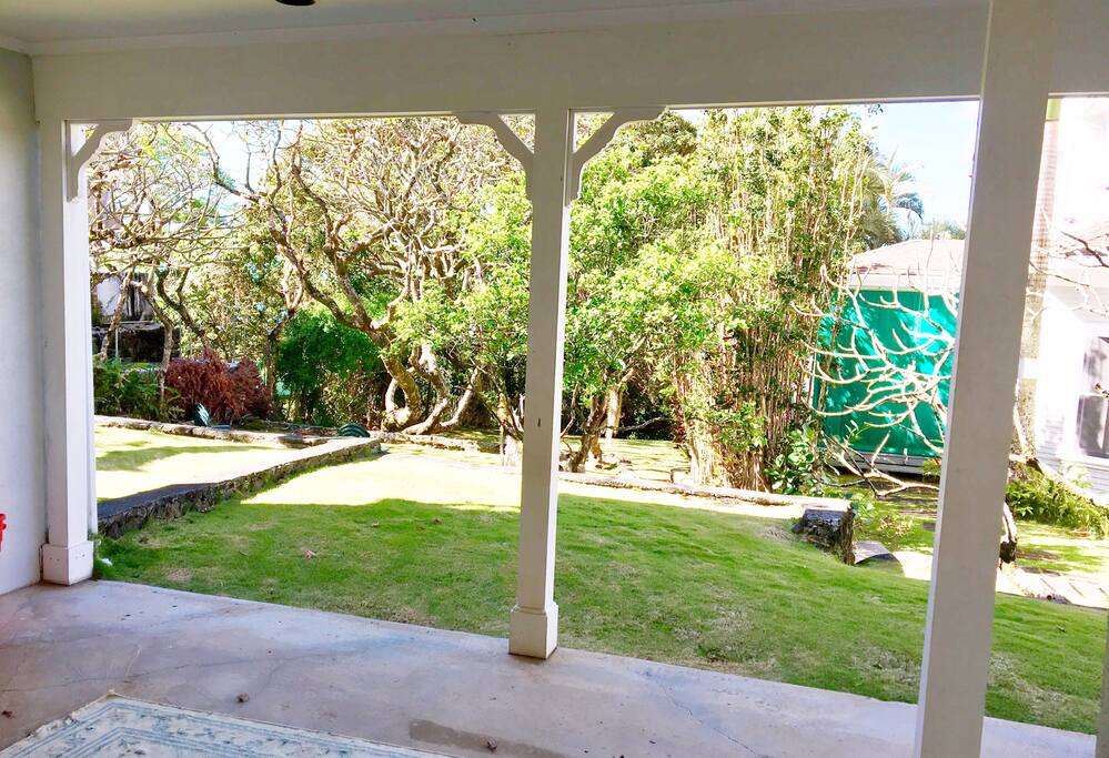 Covered lanai with view of the grounds of the historic residence.