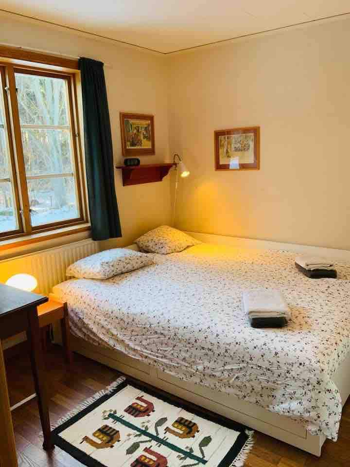 ห้องนอนชั้นล่างพร้อมโต๊ะทำงานขนาดเล็กและตู้เสื้อผ้าที่ติดตั้งไว้ 