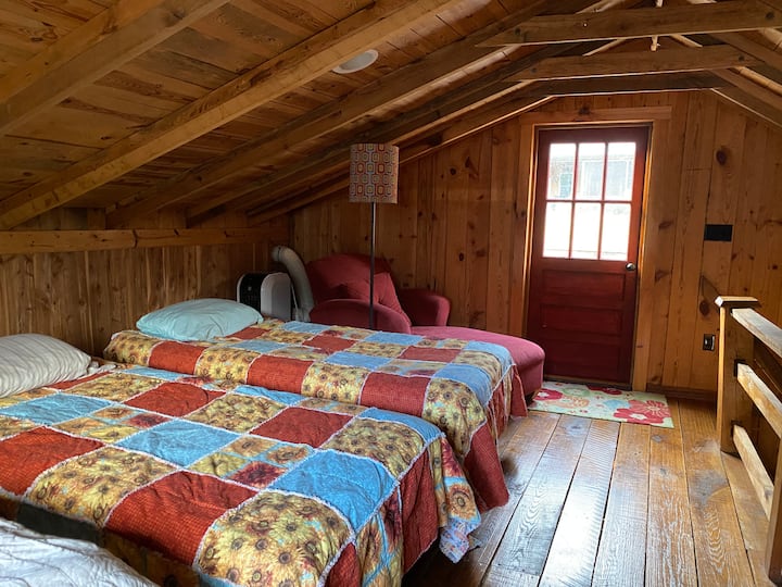 เตียงแฝด 2 หลังและเก้าอี้นั่งเล่นในห้องใต้หลังคา ดาดฟ้าด้านนอกประตู