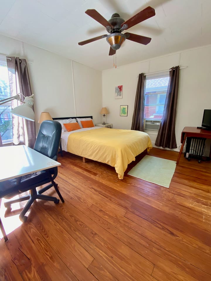 Spálňa pre hostí s písacím stolom a malým televízorom. Klimatizácia okennej jednotky.