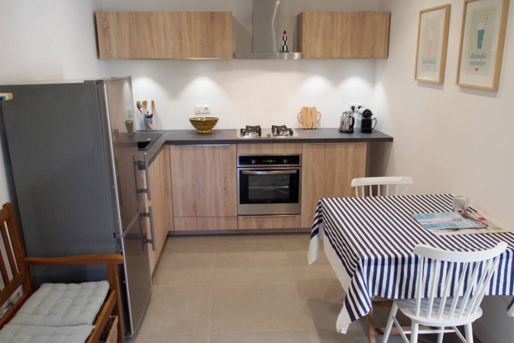 Clean, open and well equipped kitchen area with washing machine and dishwasher