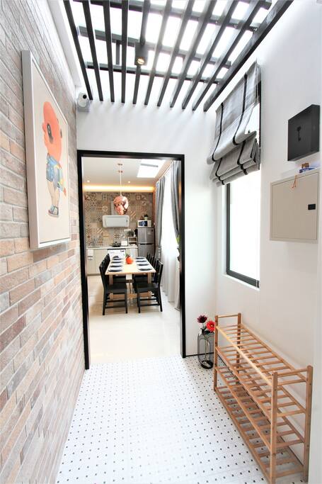 Entry way - Chic black/white floor tiles, craftstone bricks and ceiling louvers. A modern interpretation of traditional Peranakan heritage houses!