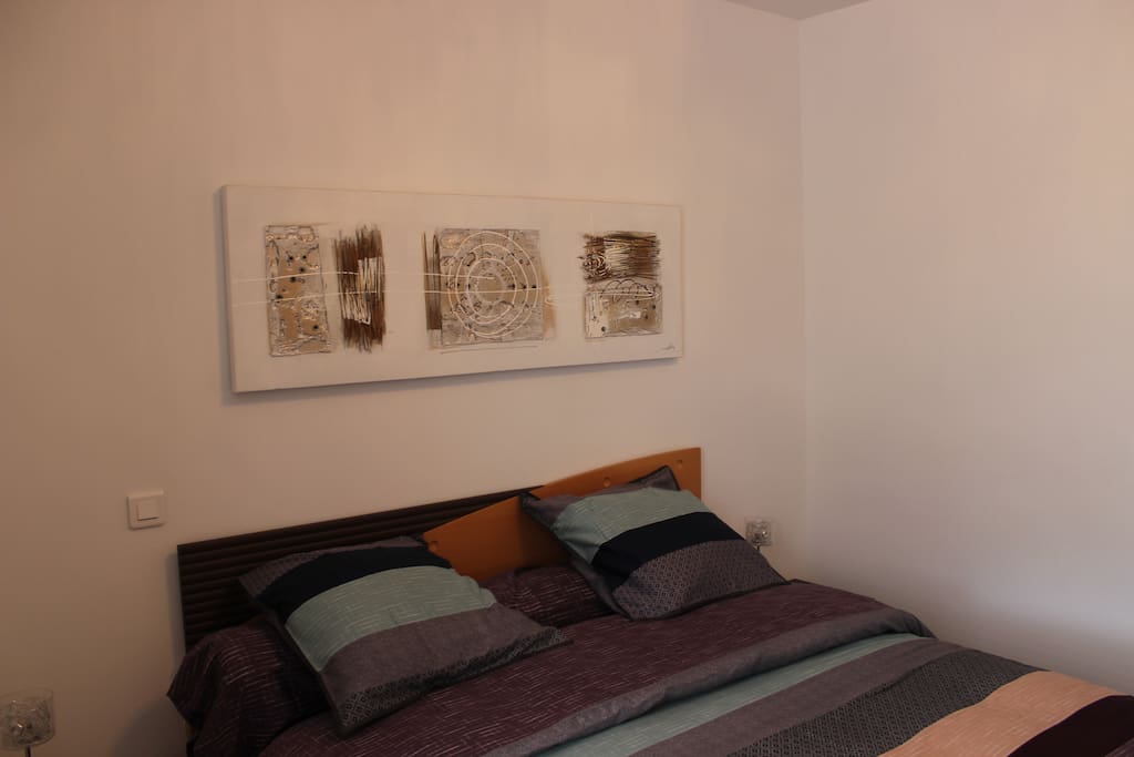 Chambre avec 1 grand lit et une armoire.