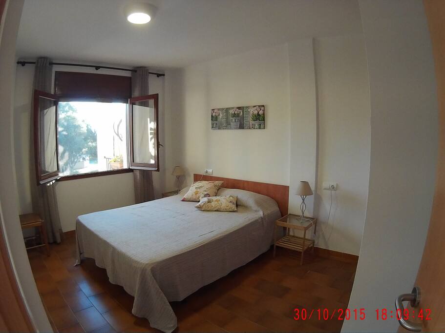 Cama de matrimonio, dos luces de mesa y una de techo. Silla.