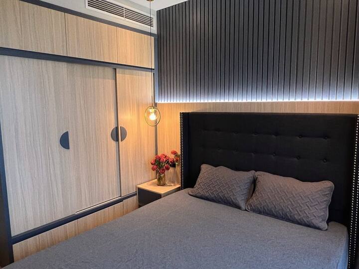 El encantador segundo dormitorio con una cama tamaño queen y un gran armario. 