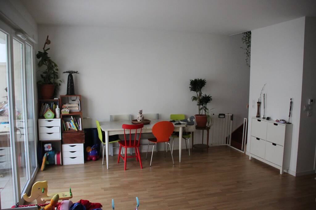 Le salon vue sur la droite avec une table à manger, accès à l'étage