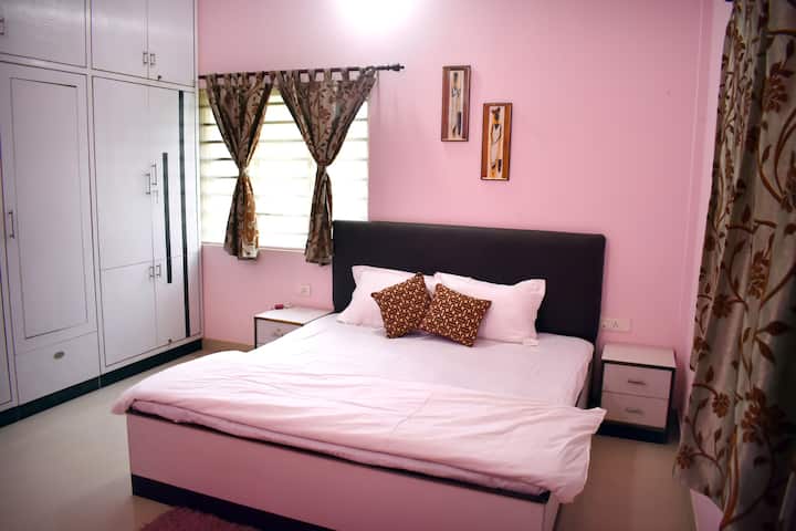 Elegant, airy Master AC bedroom with attached washroom and king size bed.