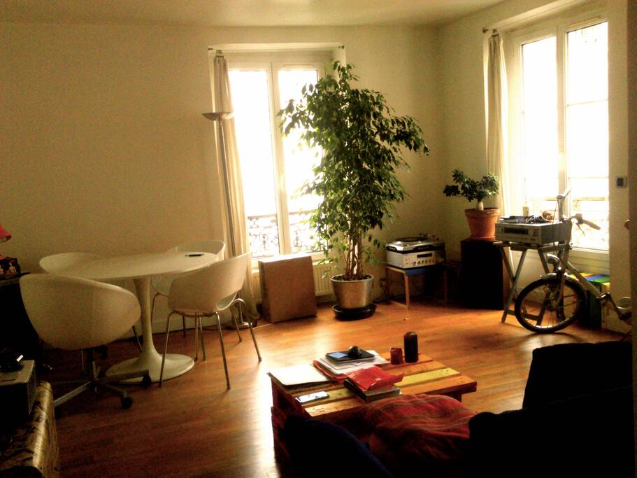Vue de la pièce principale, lumineuse et ample, avec un bureau, une table ronde et un canapé lit double. WiFi disponible.