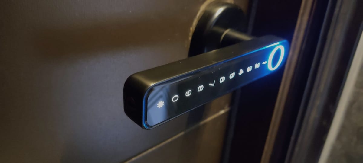 A modern electronic door lock is featured, showcasing a sleek design with a lit circular keypad. The lock is set against a dark door, emphasizing its contemporary technology and secure access features.