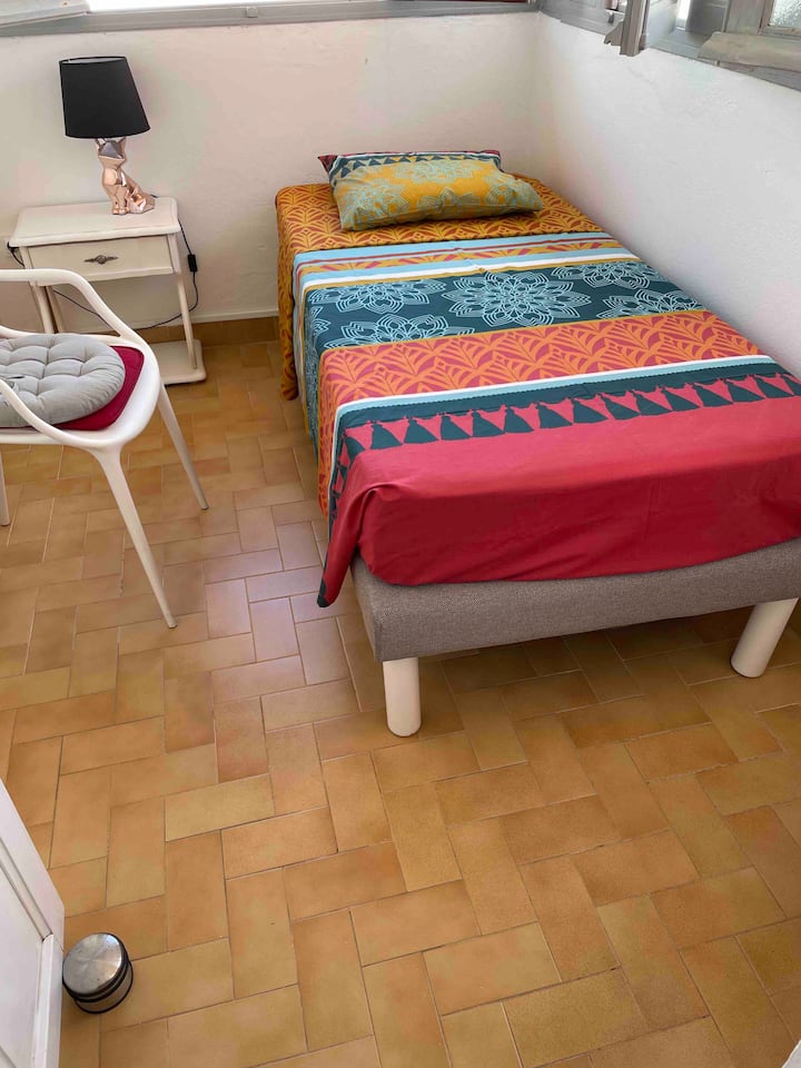 لوجيا مستقلة في الطابق العلوي مكيفة الهواء بسرير مريح 90 × 190 وطاولة بجانب السرير ومروحة. 