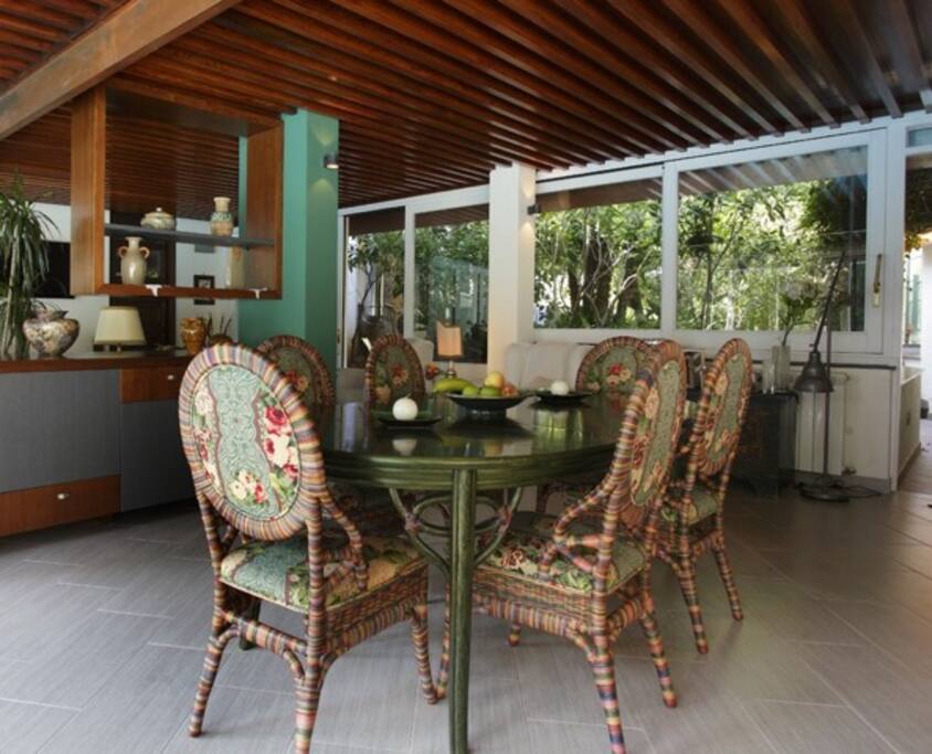 L'angolo pranzo del living con vetrate sia sulla piscina che sul rigoglioso giardino retrostante