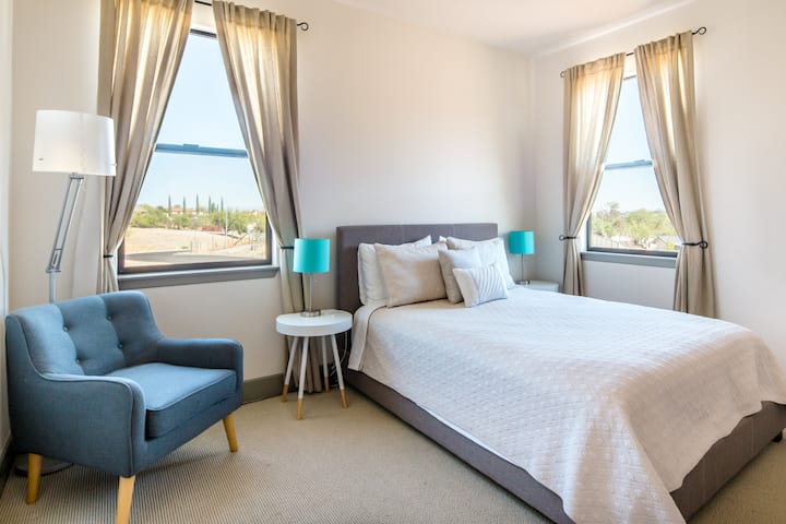 Relax in the  mid-century inspired upstairs bedroom with queen bed and great views.