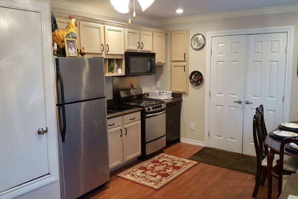 Kitchen sink, full stove, microwave, refrigerator and freezer, dining table, double door entry into restroom