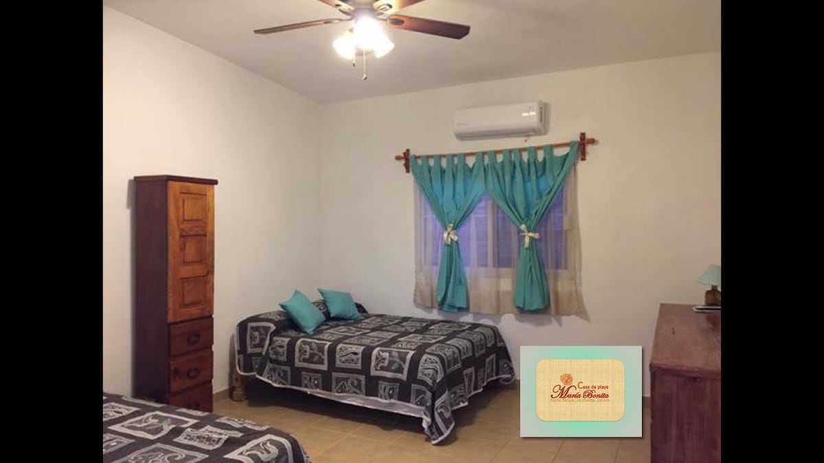 Chambre avec deux cannes doubles, climatisation et salle de bain complète.