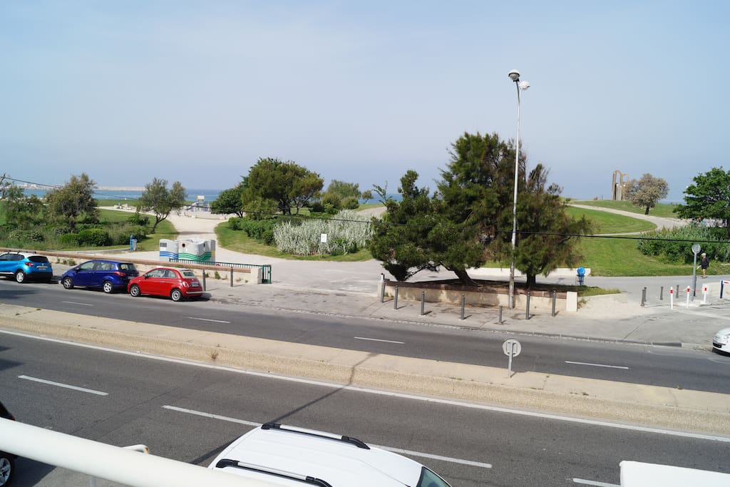 vue générale, face au logement, avec entrée de la plage et des espaces verts.