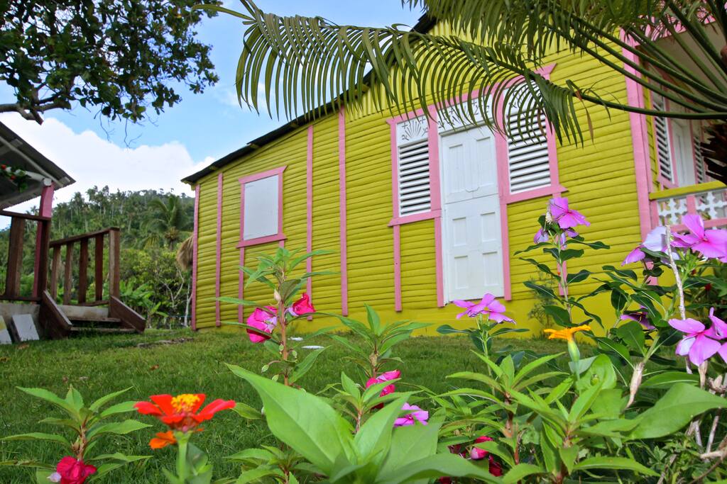 Side view of the yellow house with beautiful flowers