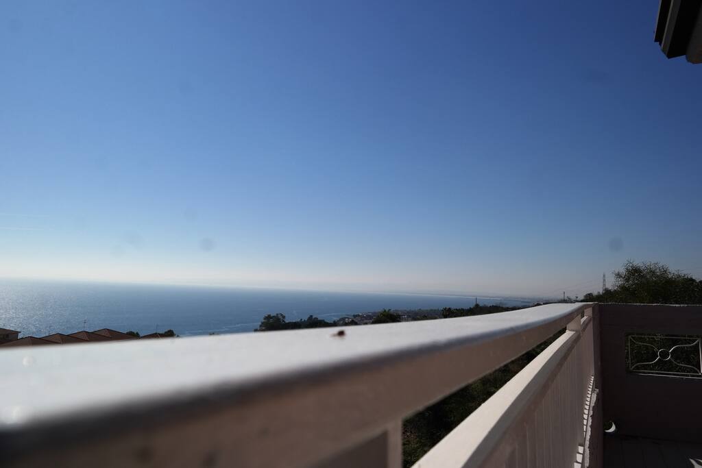 Balcone attrezzato con tavolino sedie e poltrone.