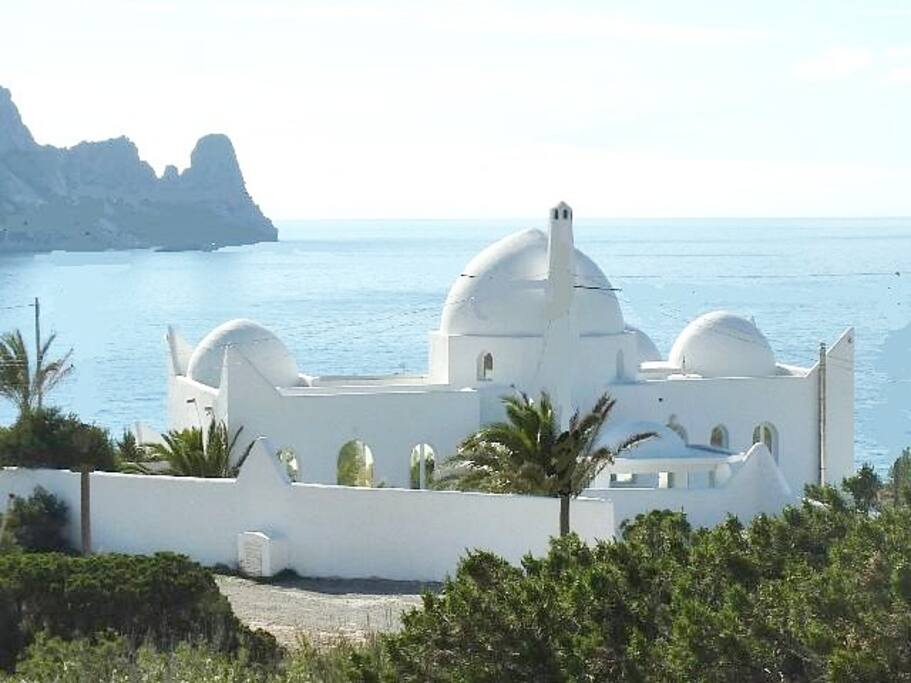Weiße Villa vor blauem Meer