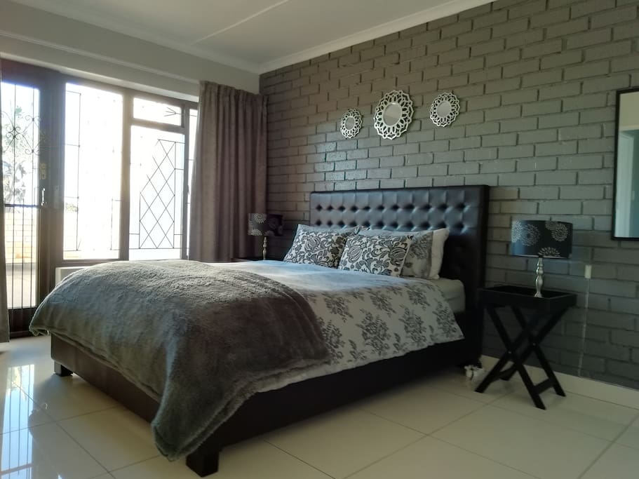 The main bedroom is upstairs with a balcony, queen bed and a bathroom en suit. There are block out curtains and an alarm pad with a panic button next to the bed. Fully secured for a peaceful night sleep. It has 4 bath towles and 1 beach towel and a complete change of linnon for the bed.