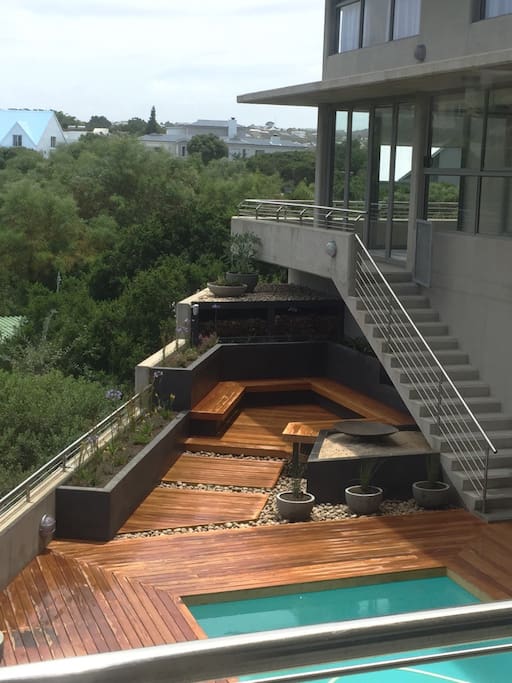 Seating area next to pool with open fire pit / braai