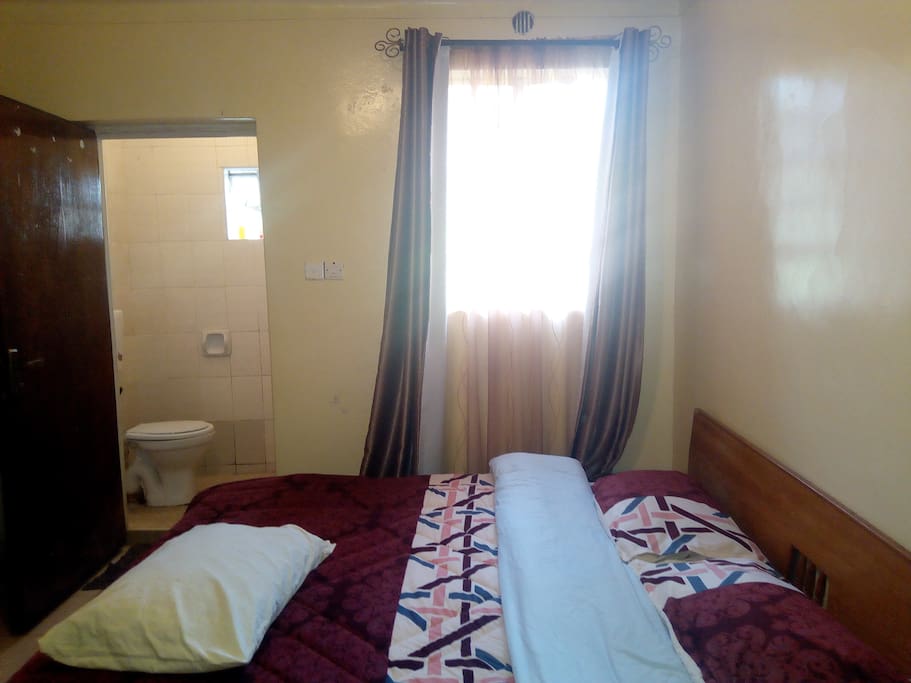 Self contained bedroom with closets and double bed.