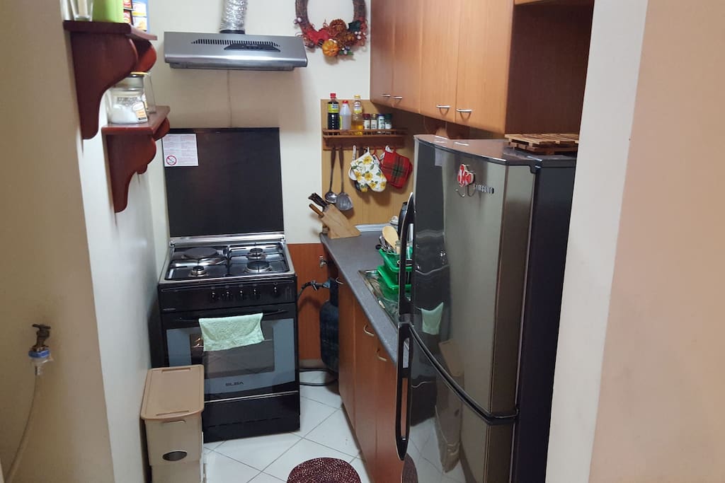This is the kitchen area with fridge/freezer, washing machine with spinner, electric stove and kettle. Plates, cutleries and cups are all included.