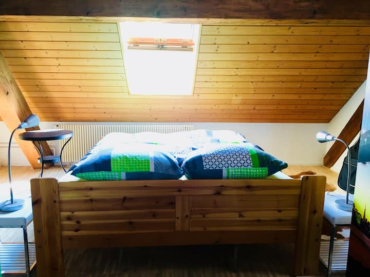 Cama en la sala de estar, separada por paravan