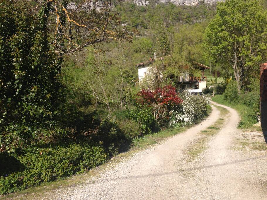 la maison vue du chemin, en retrait, dans son petit coin tranquille.