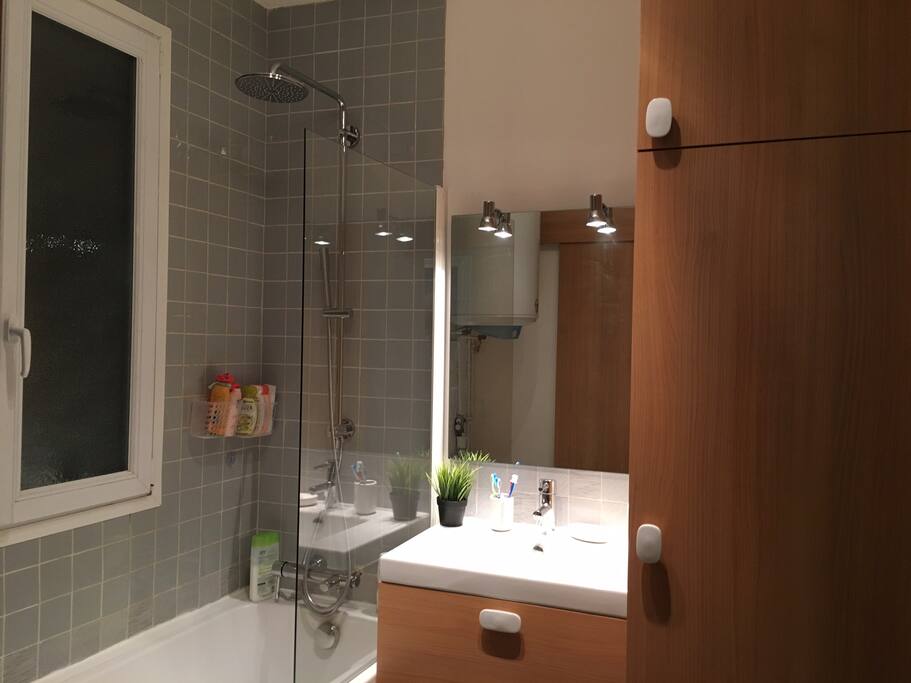 Salle de bain avec baignoire, lave-linge et sèche-linge