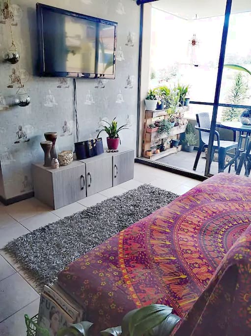 Sala con con TV compartida y balcón.