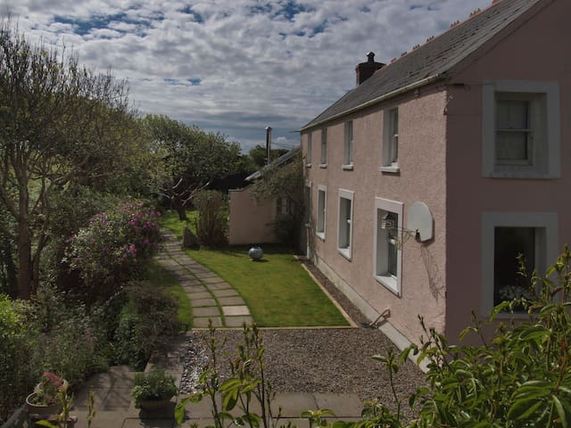 Farmhouse in sheltered valley with path to cove
