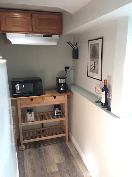 Kitchenette with coffee maker, toaster, microwave, blender, sink and fridge.