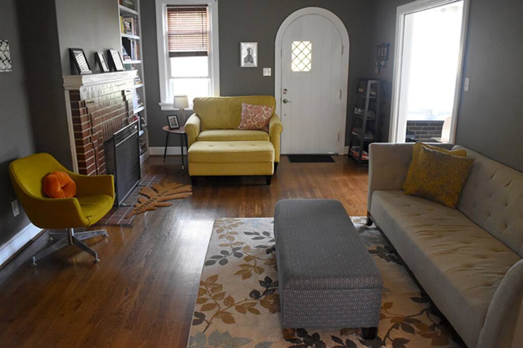 Living room with gas fireplace, bookshelf full of art books, and smart 50" TV with Bluray player and surround sound