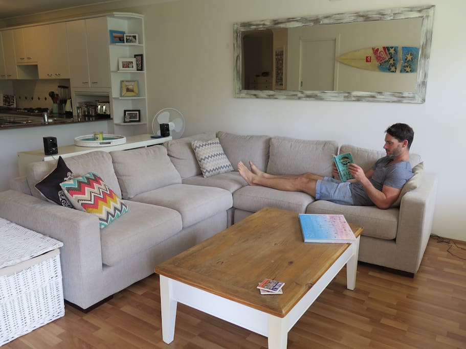 Living room, complete with comfy sofa, recycled timber coffee table and mirror.