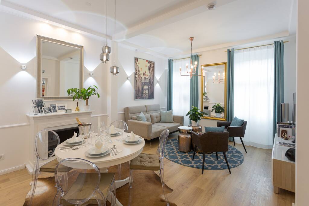 Living room, separated into a dining area and a comfortable reception area.