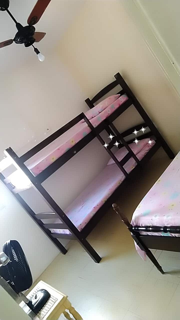 Dormitorio con cama plegable y cama de una plaza. Ventilador de techo y ventana.
