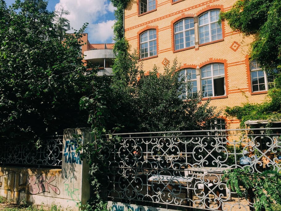 Backyard with an old fabric building, in which a coffeeshop and an cowering space is located.. good coffee just in the backyard for a fresh start in the day