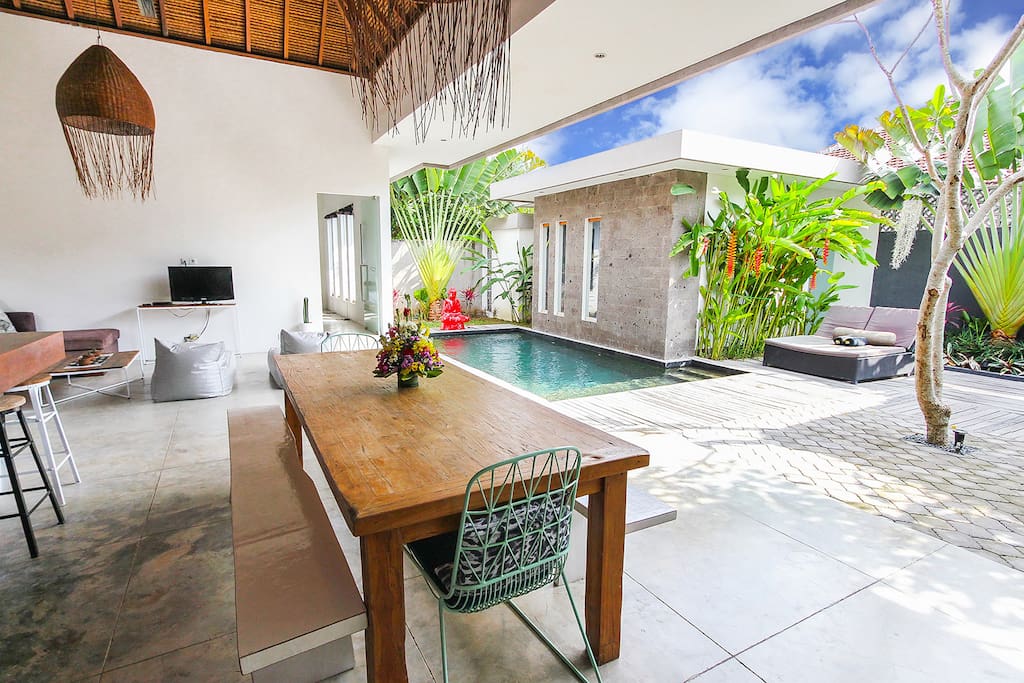 View of the dining table through open plan living to the pool and bedroom 3 / ensuite.