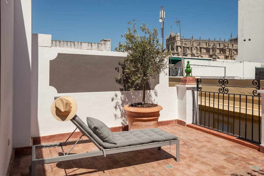 Terraza con tumbonas para tomar el sol con preciosas vistas de la Catedral y de las azoteas sevillanas