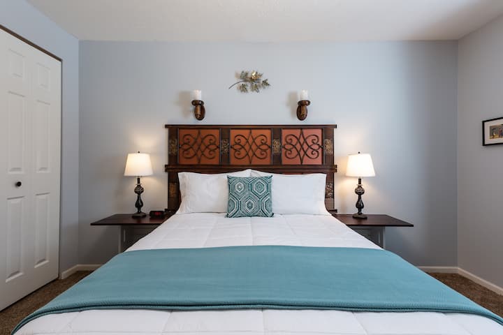 Dormitorio trasero: colchón queen con mesitas de noche y luces