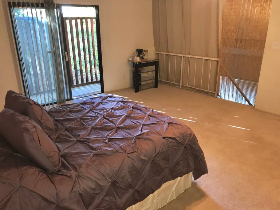 Comfy queen size bed with view of the private patio.